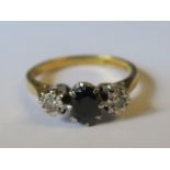 An 18ct gold sapphire and illusion set diamond three stone ring, finger size P, 3.8g gross