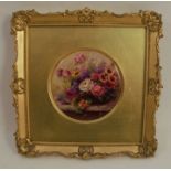 A Royal Worcester circular porcelain plaque, decorated with a still life study of flowers on a ledge