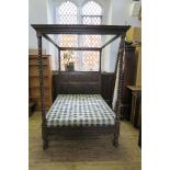An Antique oak four poster bed, with barley twist columns, and fielded panels to the back board,