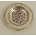 A silver circular dish, the centre embossed with a flower head, London 1953, weight 3oz