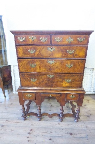 An 18th century walnut chest on stand, having two short drawers, over three long graduated long
