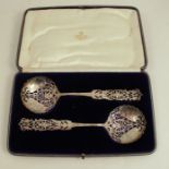 A pair of cased silver pierced silver spoons. decorated with scrolls and flowers, London 1908,