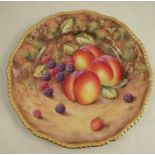 A Royal Worcester plate, decorated with hand painted fruit by Love, to a gadrooned border,