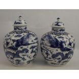 A pair of covered Chinese vases, decorated all around with dragons, Chinese seal mark to the base,