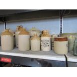 A collection of stoneware flagons, jars, mugs etc, and two glass bottles