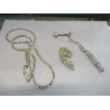A white metal stone set ribbon shaped brooch, 16g gross, together with a silver key shaped brooch