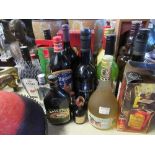 A collection of bottles of alcohol, including Advocat, wines, Bell's whisky, Amaretto, etc.