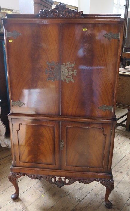 A modern mahogany drinks cabinet, the upper section having a pair of doors opening to reveal