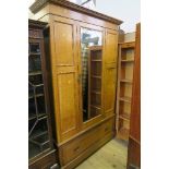 An Arts and Crafts style mirror door wardrobe, the mirror door opening to reveal hanging space, over