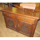 An oak sideboard, fitted with two drawers over two cupboard doors, with carved decoration, width