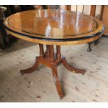 An oval walnut loo table, with ebonised and satinwood inlay, raised on a modern mahogany base,