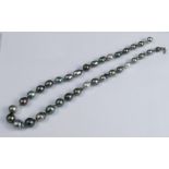 A graduated row of baroque black cultured pearls, to an 18 carat white gold clasp, 52cm long