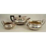 A Georgian silver three piece tea set, with gadrooned lower body and engraved decoration, London