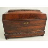 A 19th century rosewood tea caddy of sarcophagus form, the interior fitted with a well with cut