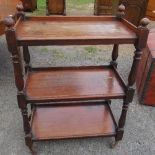A 19th century mahogany three tier buffet, with turned supports, on wheels, 28ins x 16is x  height