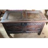 An antique oak coffer, with carved panels to the front, width 38ins, depth 19ins, height 21ins