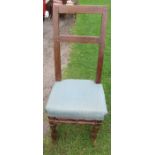 A primitive chair, with upholstered seat and turned front legs united by a stretcher