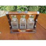 A 19th century oak tantalus, with square glass decanters with key, bearing presentation plaque,