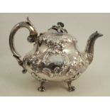 A Victorian silver teapot, with embossed decoration and flower finial, engraved with a crest, raised