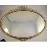 An oval wall mirror, with gilt frame and gilt ribbon decoration, overall diameters 27ins x 35ins