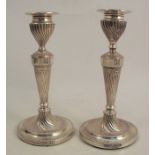 A pair of Victorian silver candlesticks, with bead edge, fluting to the sconce, column and base,