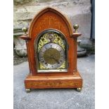 An Edwardian walnut cased mantel clock, with gilt arched dial and silvered chapter ring, the 8 day