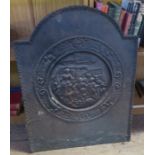 A cast iron fire back, decorated with figures in a roundel, 24ins x 18ins