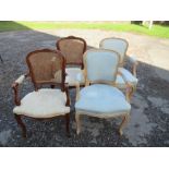 A pair of cane back open armchairs, together with a pair of similar chairs with upholstered backs,