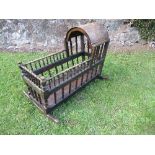 A late 19th century rocking child's crib, with a canopy and faux bamboo turned spindle supports,