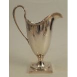 A silver jug, with ribbed edge and handle, raised on a pedestal to a square foot, Birmingham 1989,