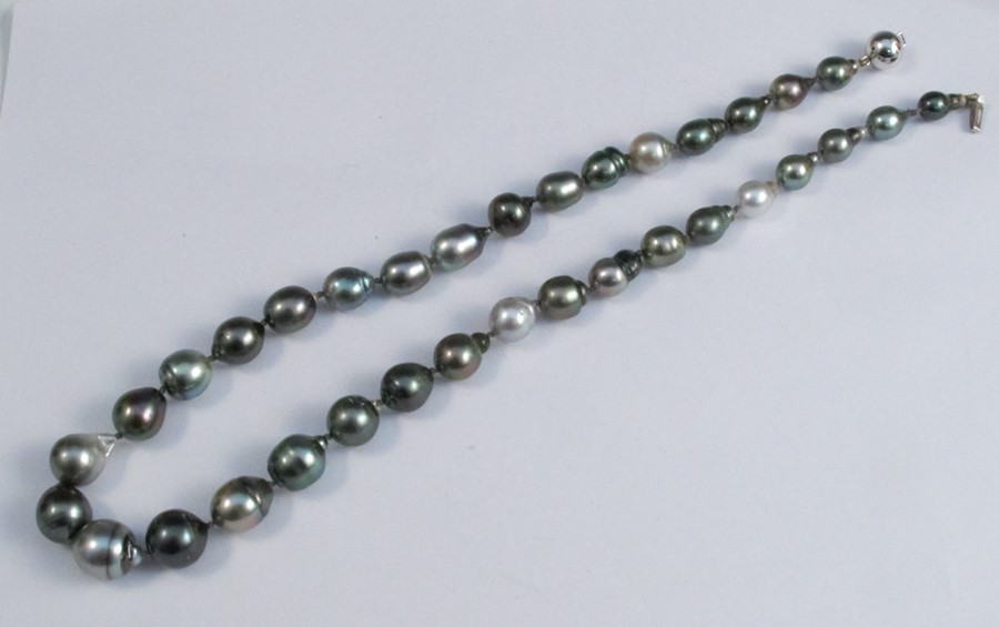 A graduated row of baroque black cultured pearls, to an 18 carat white gold clasp, 52cm long
