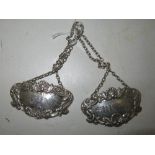 A pair of hallmarked silver Sherry and Gin decanter labels, with scroll and foliate border, London