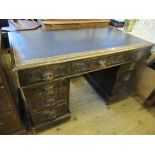 An Edwardian oak desk, with central drawer flanked by four drawers to each side, with lions mask