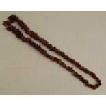 A graduated row of raw amber beads, 72cm long, 64g gross