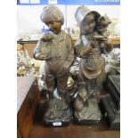A pair of bronzed effect plaster models, of children holding puppies and kittens, height 19.5ins