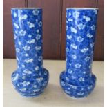 A pair of oriental vases, decorated with prunus to a blue ground, character marks to the base,