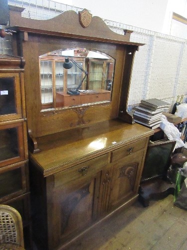 An Edwardian Art Nouveau style mirror back sideboard, with two drawers over two part carved doors,