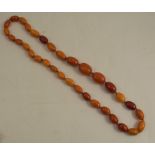 A graduated row of oval reconstituted amber beads, 94cm long, 166g gross