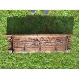 A wooden over mantle wall shelf, carved with a figure on a tow path with a narrow boat, trees and