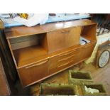 A 1960's sideboard, with central flap, sliding glazed panels to the sides and drawers below, width