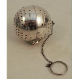 A silver tea infuser, of ball form, hinged to the centre, Sheffield 1910, on a chain with suspension