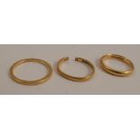 A 22 carat gold plain wedding ring, cut, together with two others, 7.4g gross