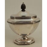 A silver sugar box, of elongated octagonal for, with hinged cover, ribbed edges, raised on a