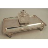 A silver desk stand, of rectangular form, with gadrooned edge, having two pen wells and fitted