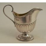 A silver jug, with gadrooned lower body, raise don a pedestal to an oval foot, Sheffield 1893,