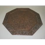 An octagonal shaped copper Eastern design tray, decorated with central foliage to a pierced