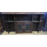 A set of mahogany wall shelves, the central two door cupboard with stain glass and Art Nouveau