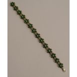 A Tsavorite set 9 carat gold bracelet, composed of fourteen flower head clusters, 20cm long, 18g
