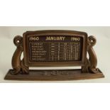 A 20th century Art Deco cast bronze desk top calendar, having dolphin supports, and marked with