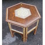 An Eastern style hexagonal table, with inlaid decoration and carving to the sides, diameter 25ins,